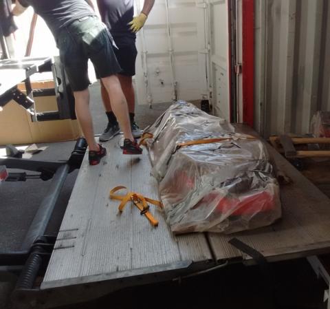 Coffins wrapped in plastic to keep them stabilized are loaded into a moving van. coffin ready to be put into the moving van
